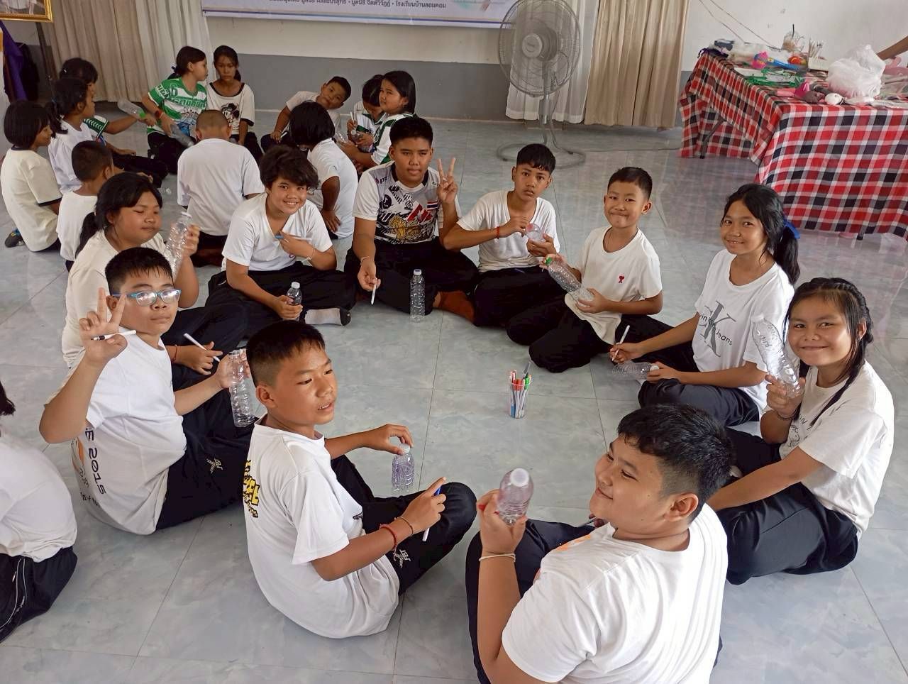 Older students sitting together holding Heart Bottles